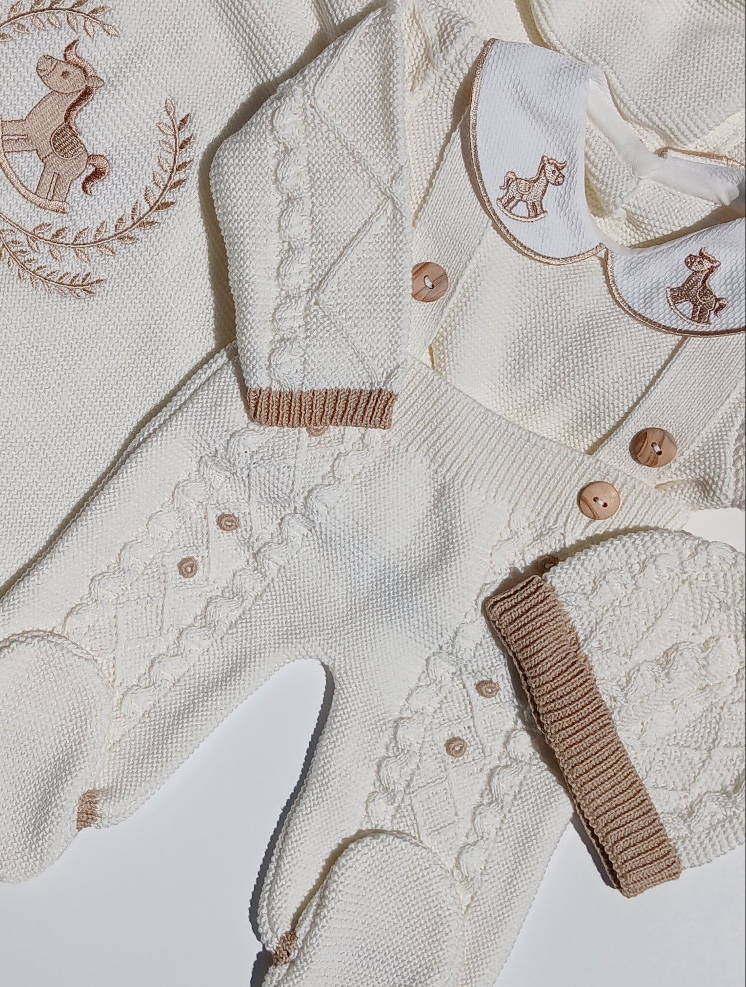 Baby outfit set with 'baby name' embroidered on a white surface Newborn knit outfit for baby coming home from hospital, rocking horse embroidery on the collar of the outfit, and baby's name embroidery
