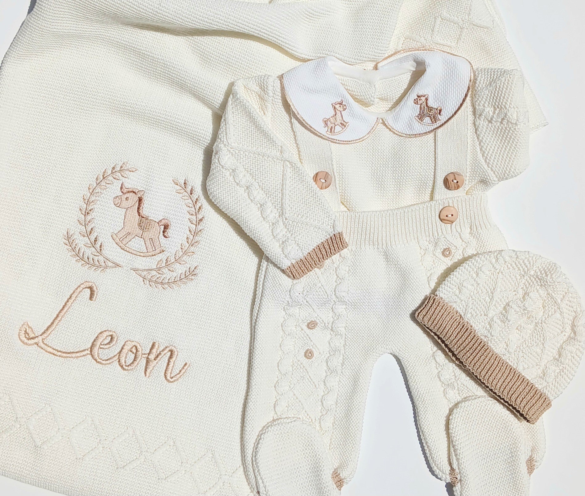 Baby outfit with cardigan, romper, and hat on a white background