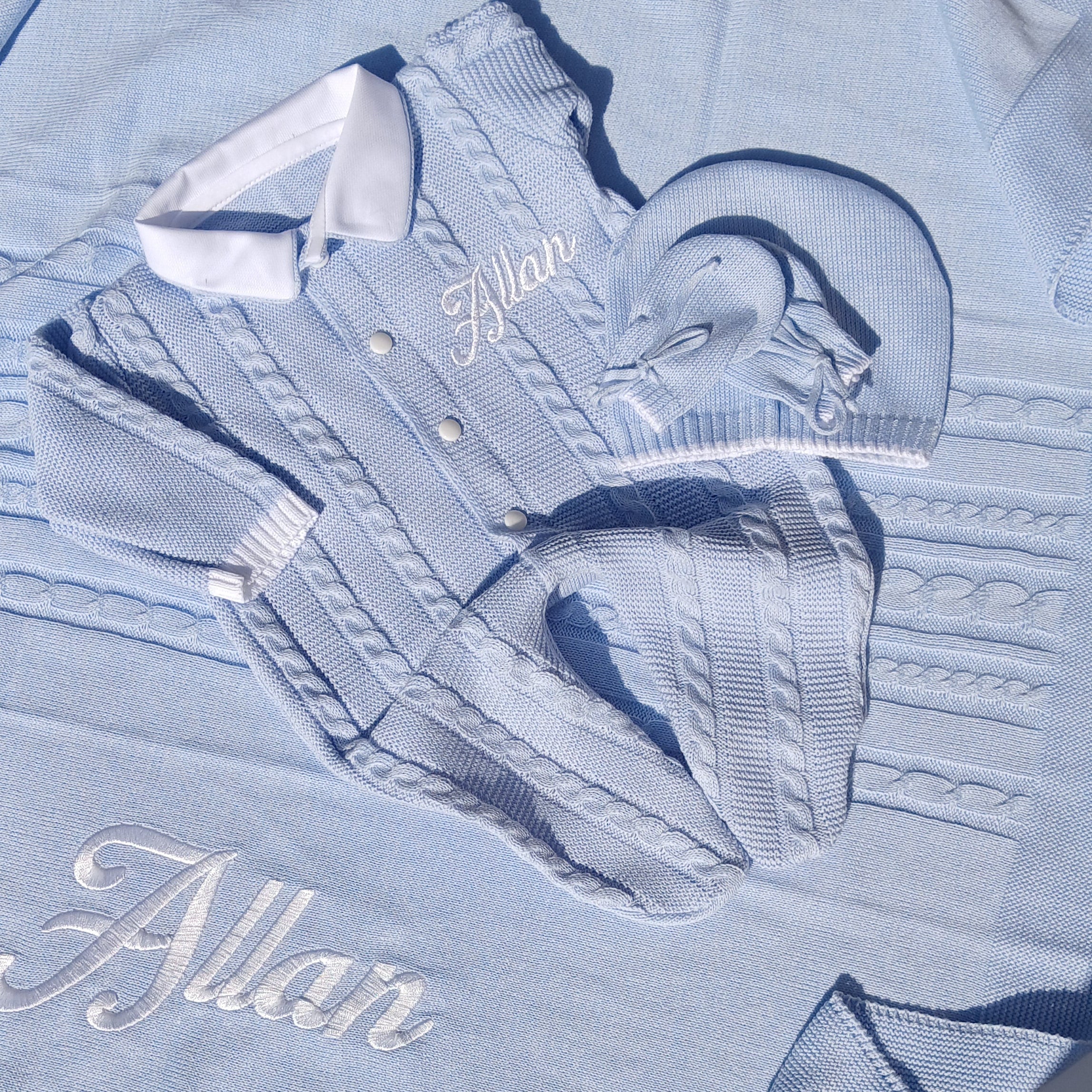 Light blue denim shirt with embroidered design and text on a white surface.