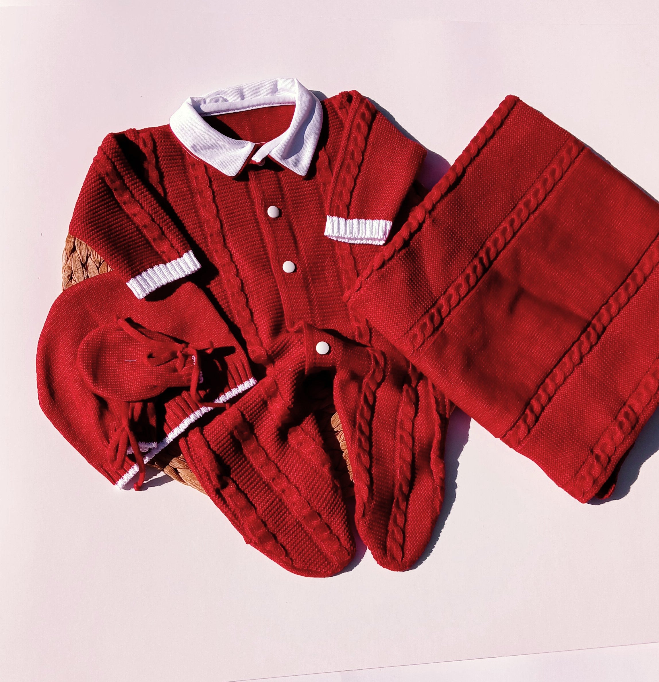 Red knitted cardigan with white buttons on a light purple background, Celebrate the season in style with this charming boys Christmas outfit