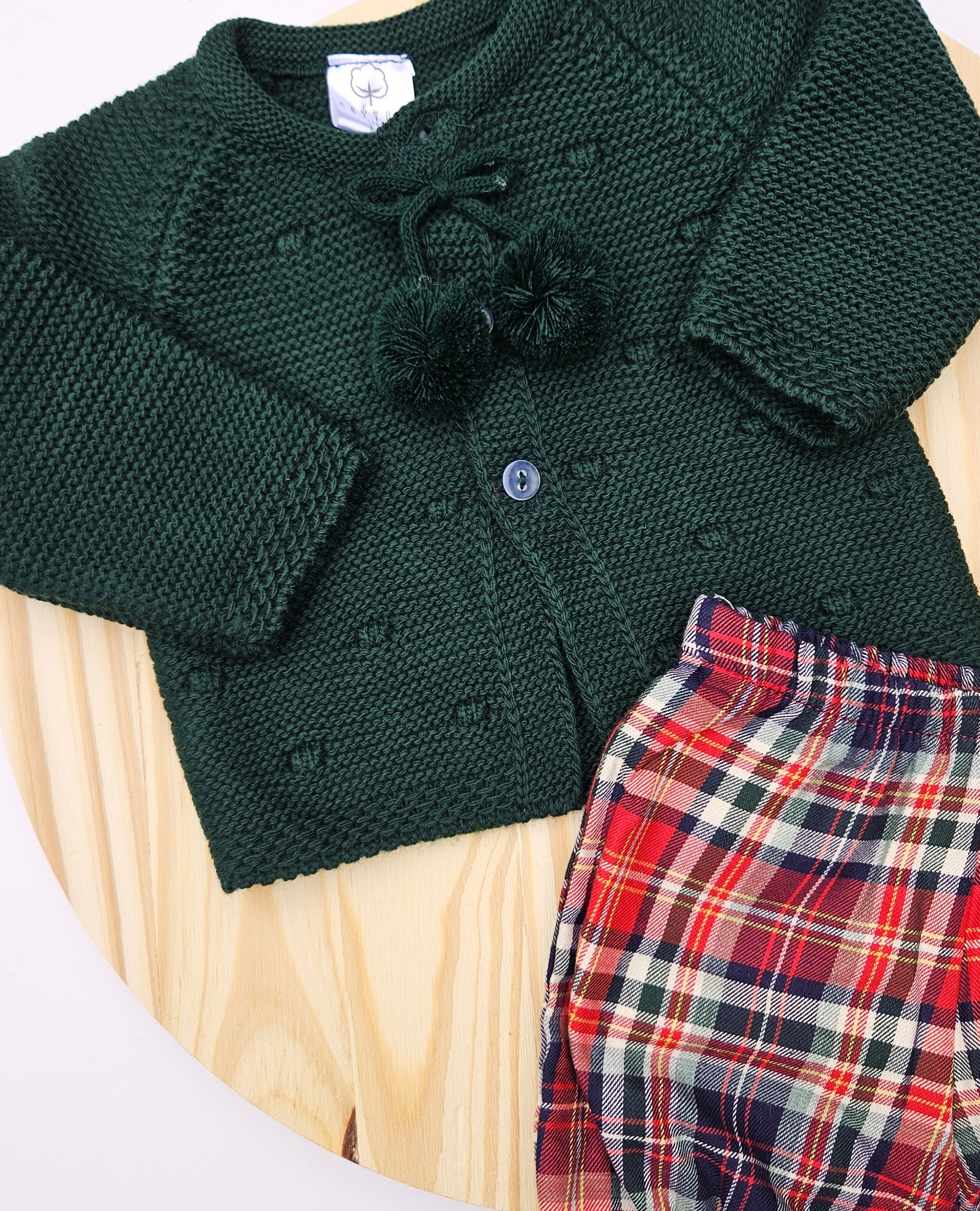 Celebrate the season in style with this charming boys Christmas outfit featuring a cozy knitted sweater paired with a coordinating plaid bloomers. This two-piece set keeps your little one comfortable and festive all day long. The classic color options make it perfect for holiday photos. Easy to dress and undress.