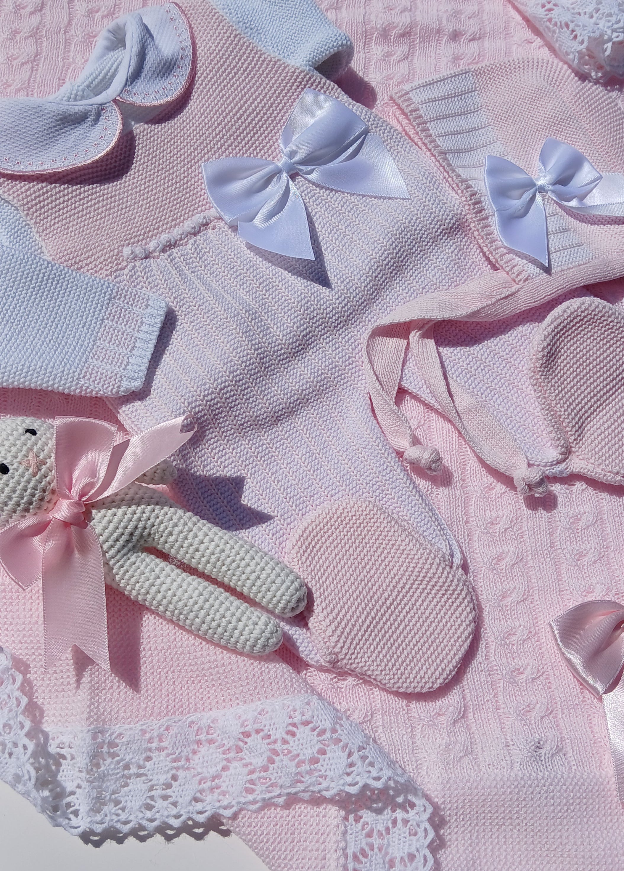 Baby outfit with pink and blue elements on a pink background