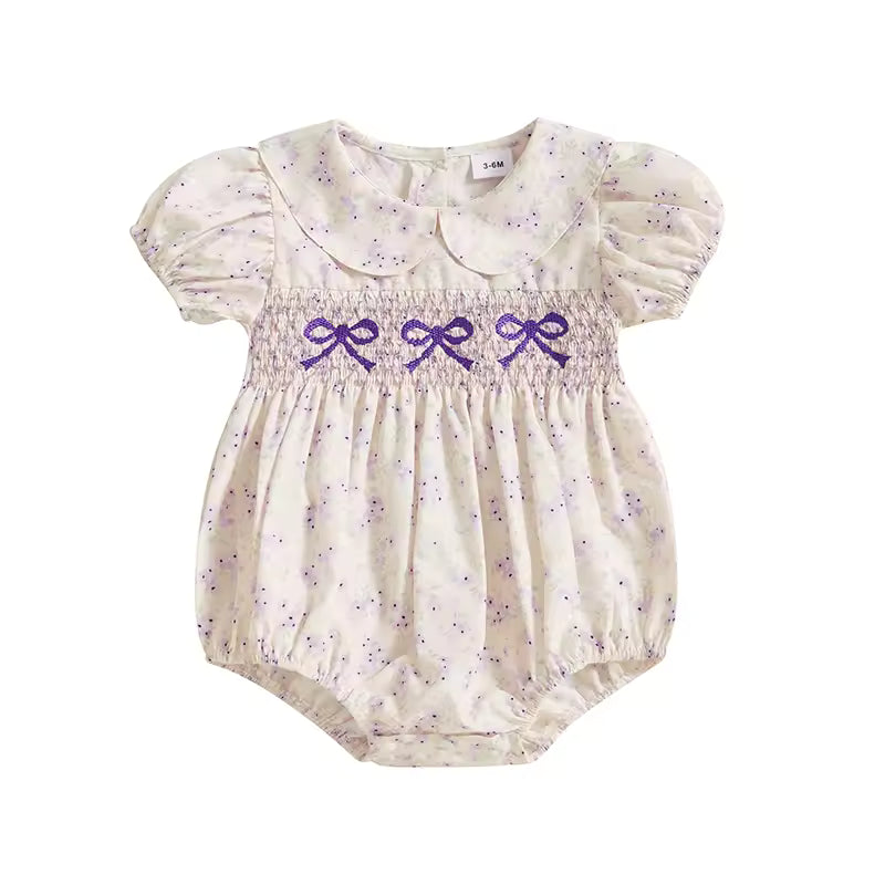 Baby romper with purple bows on a white background
