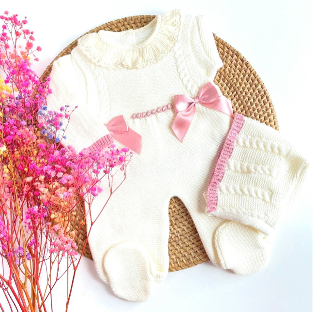 White baby outfit with pink details on a woven mat with pink flowers., newborn knit going home outfit, newborn baby girl coming home knit outfit