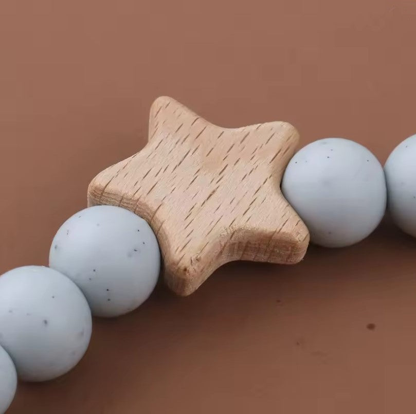 star pacifier chain, teething silicone beads, silicone beads baby pacifier chain Wooden star-shaped teether with light blue silicone beads on a brown background