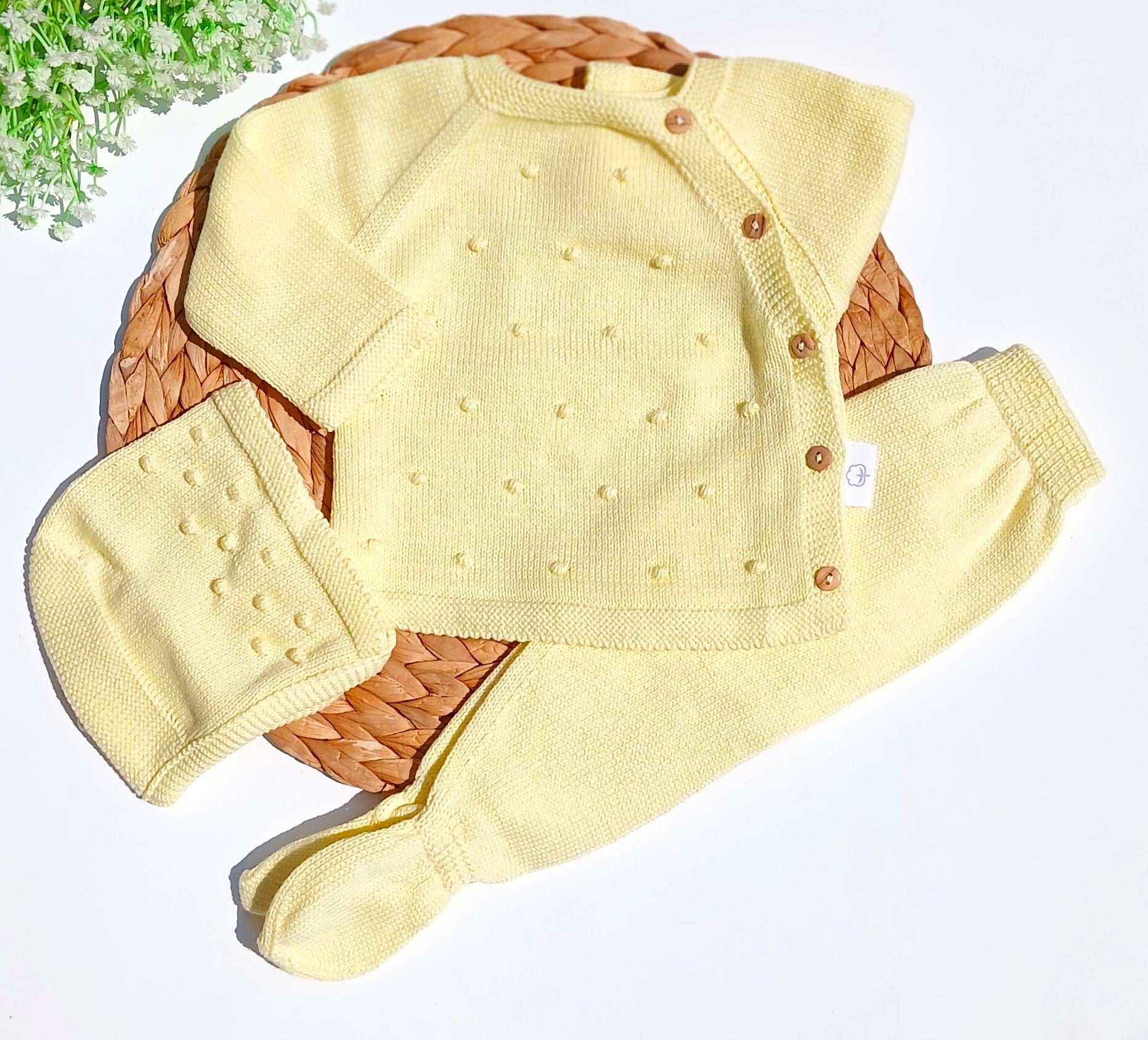 Yellow baby outfit with hat and booties on a white background