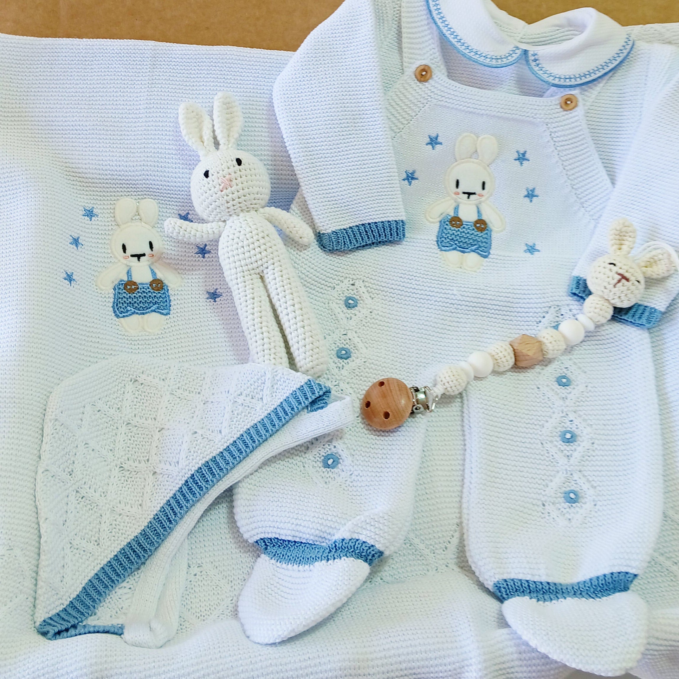 Baby gift set with white and blue items on a brown envelope