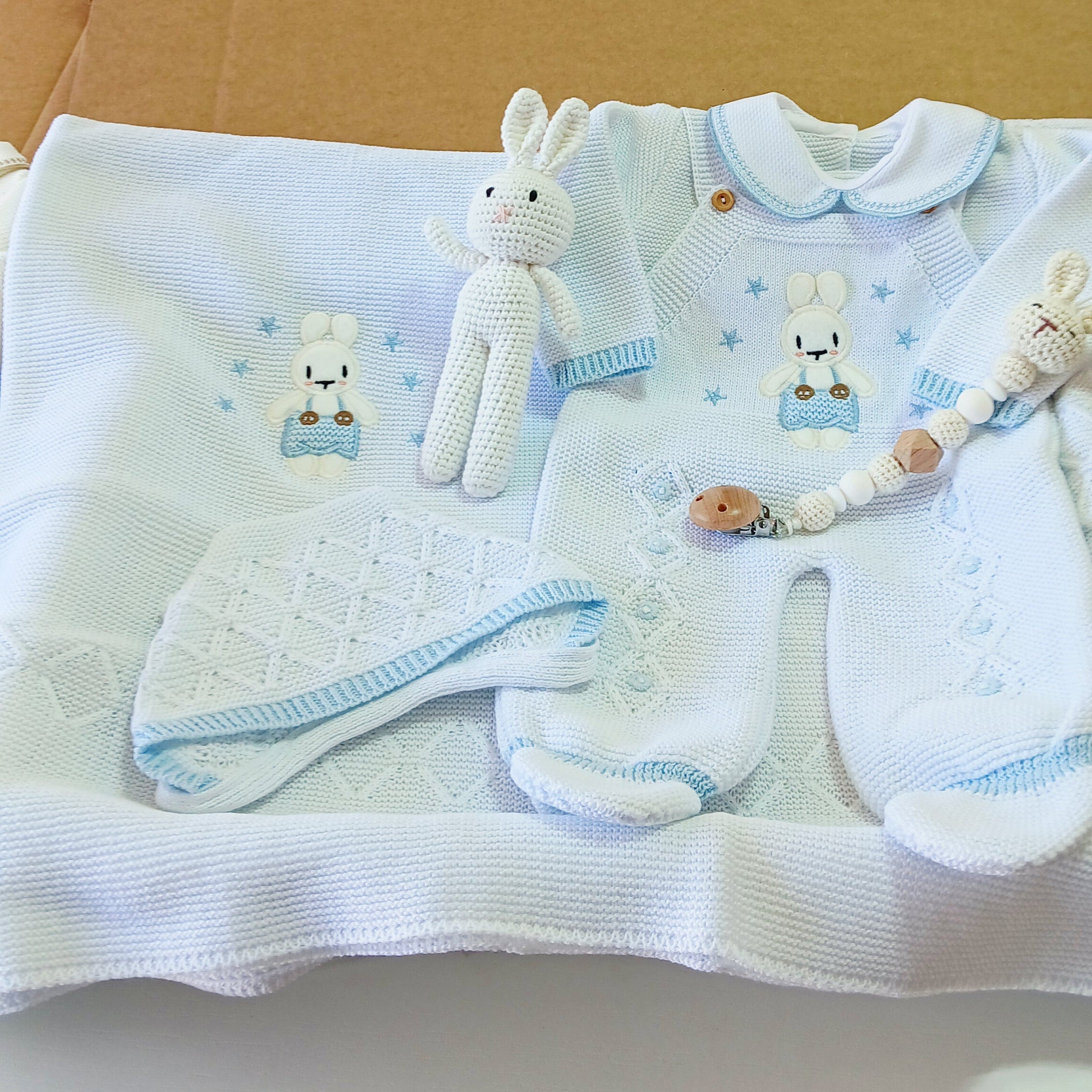 Baby clothes and diapers displayed on a stand with a white background