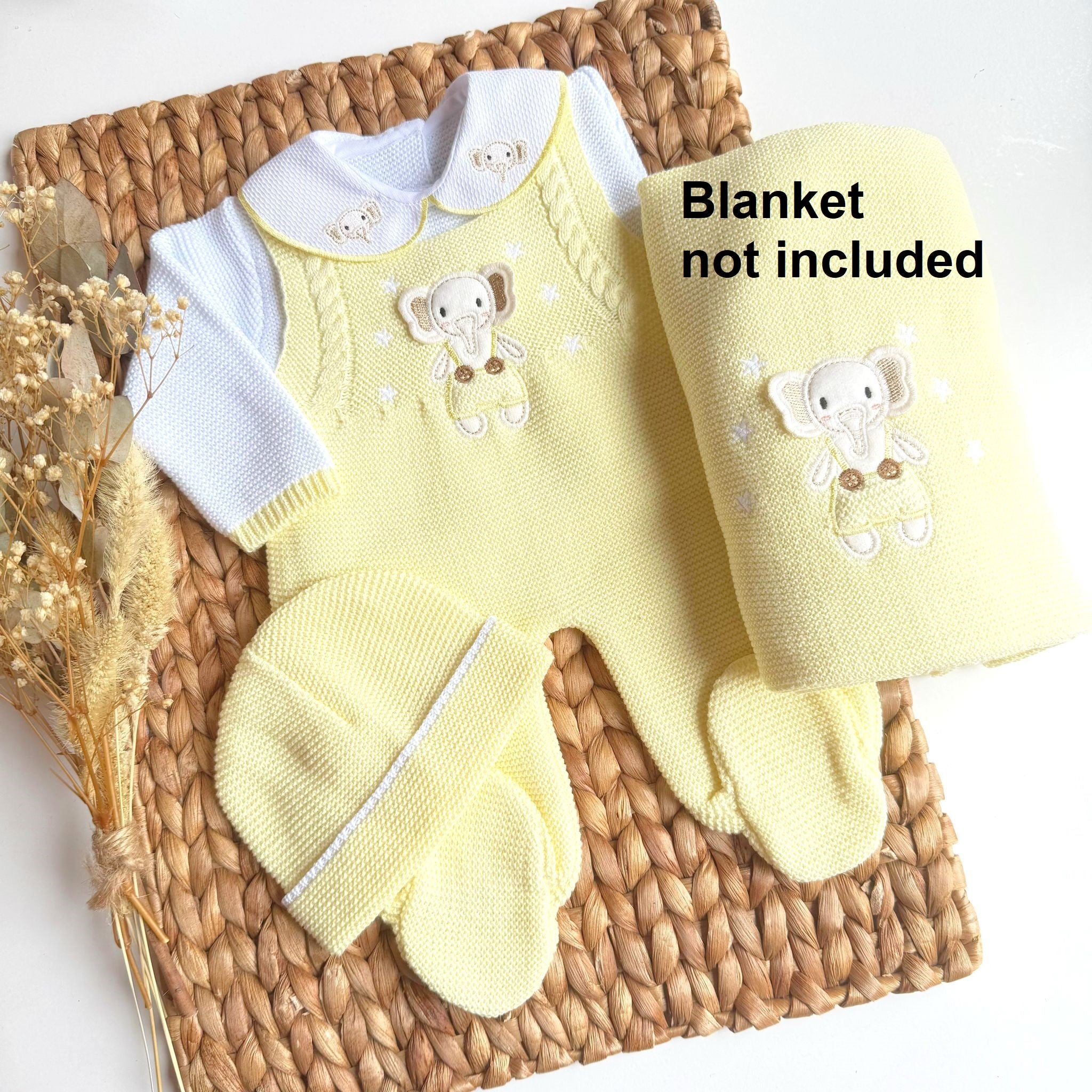 Yellow baby outfit with matching blanket on a woven surface, excluding the blanket.