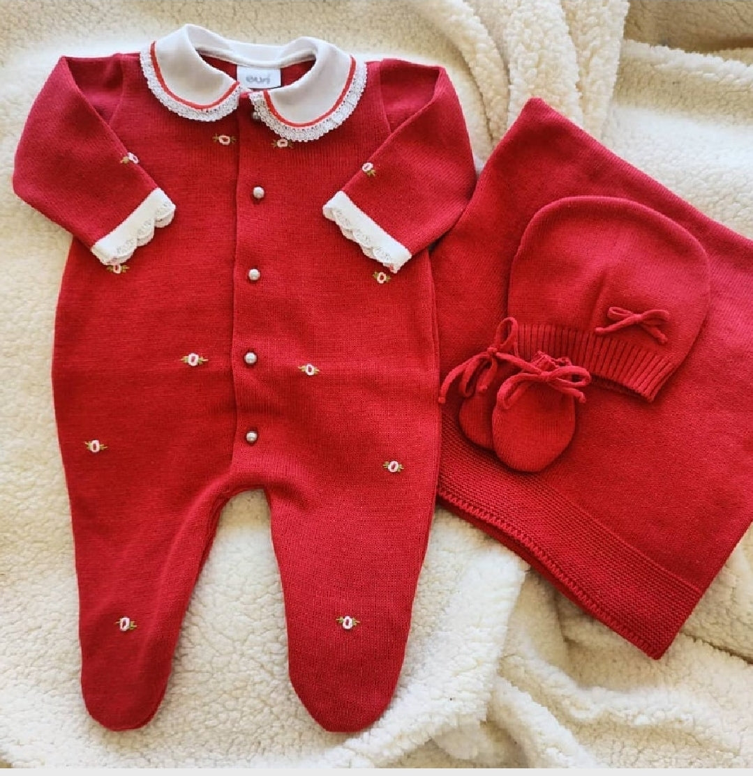 Red baby outfit with white collar and matching hat on a beige blanket