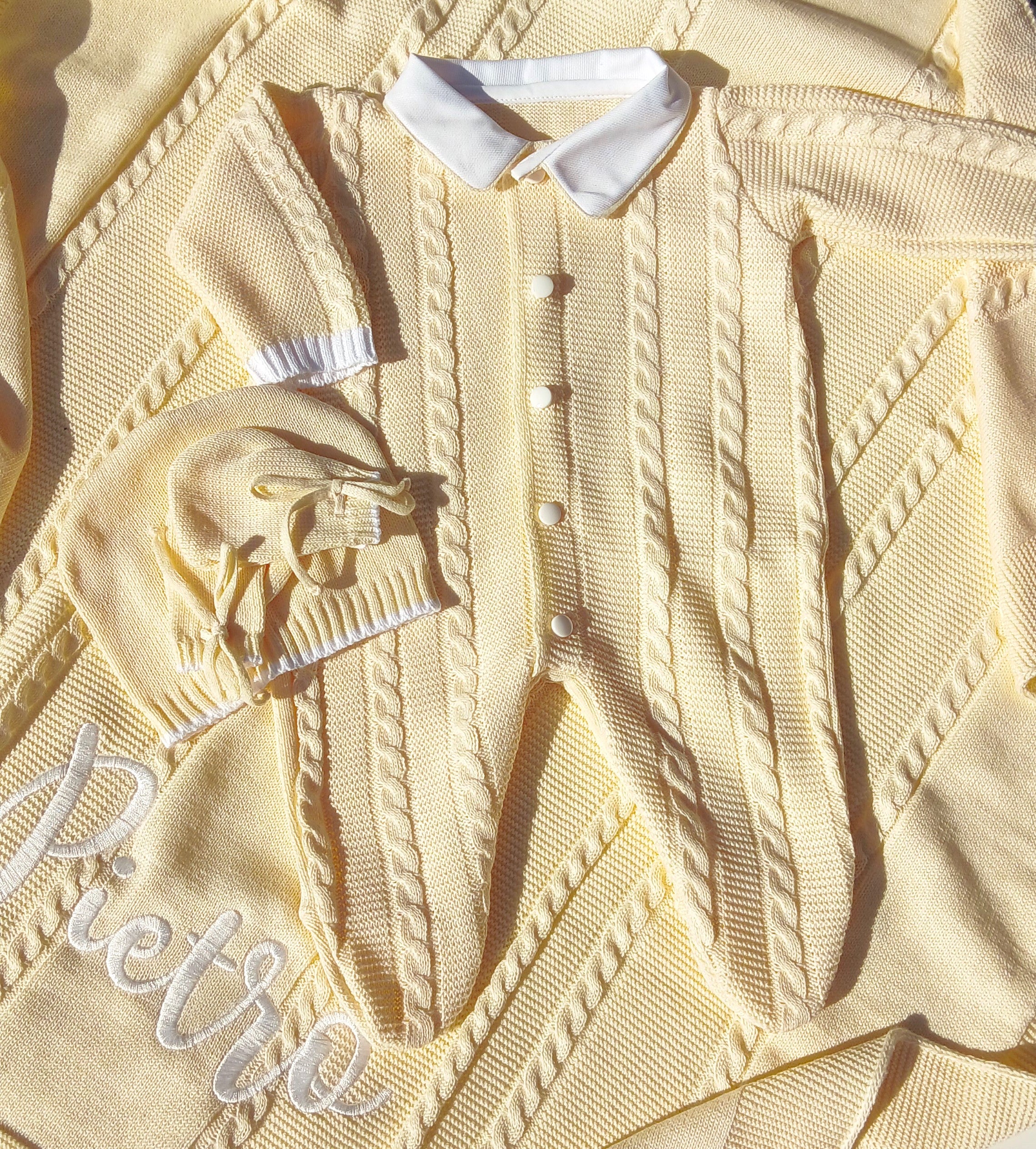 Close-up of a beige textured fabric with embroidered text and buttons.