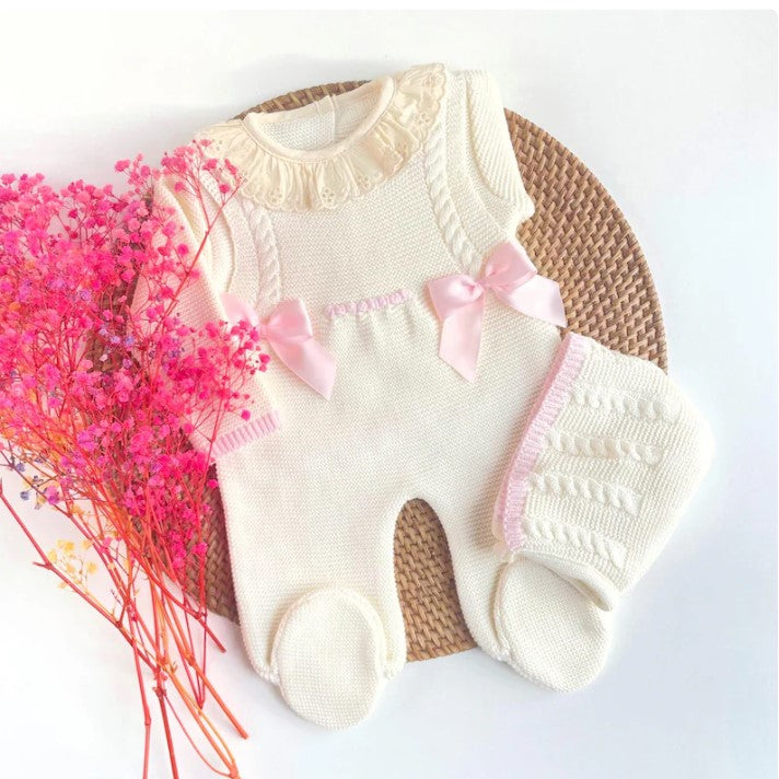 Baby romper with pink bows on a white background