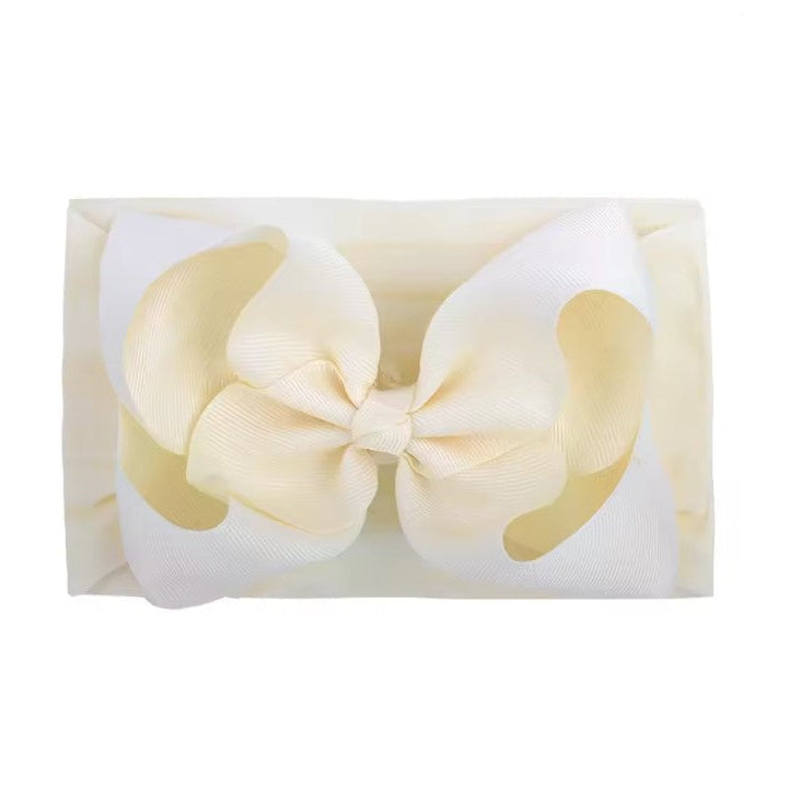 Cream-colored bow on a white background baby ribbon, large baby bow, baby headband