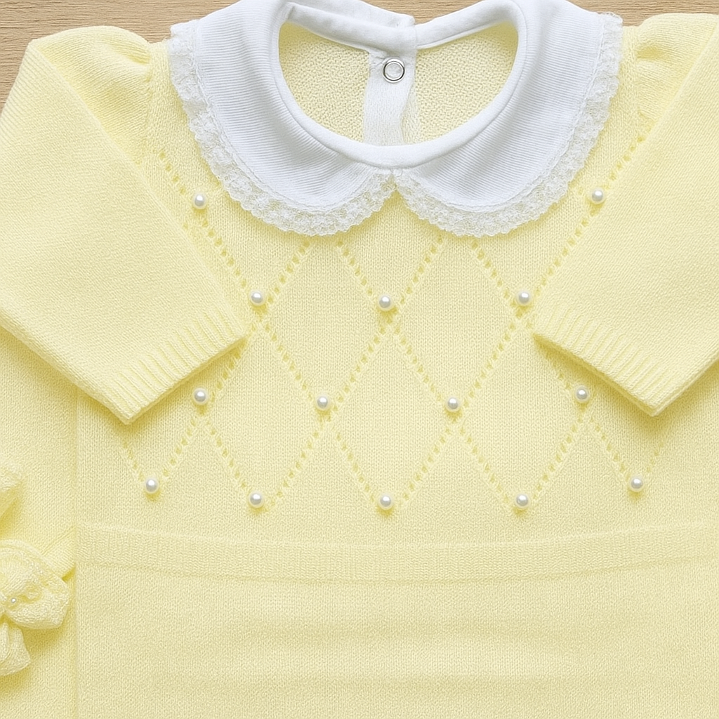 Yellow sweater with white lace collar and pearl details on a wooden surface