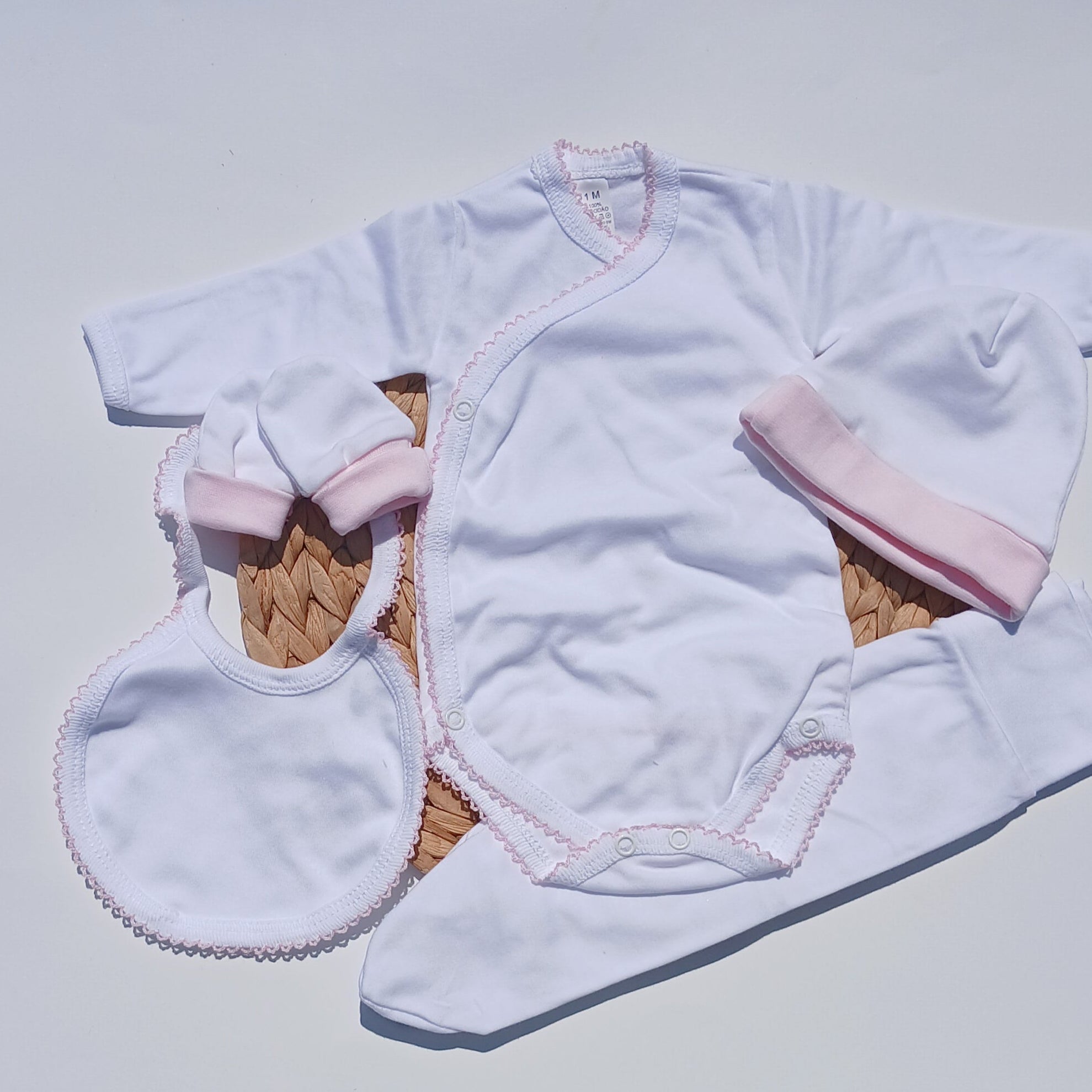 picot trim made with cotton bib, mittens hat included Baby outfit with white romper, pink headband, and white booties on a white surface.