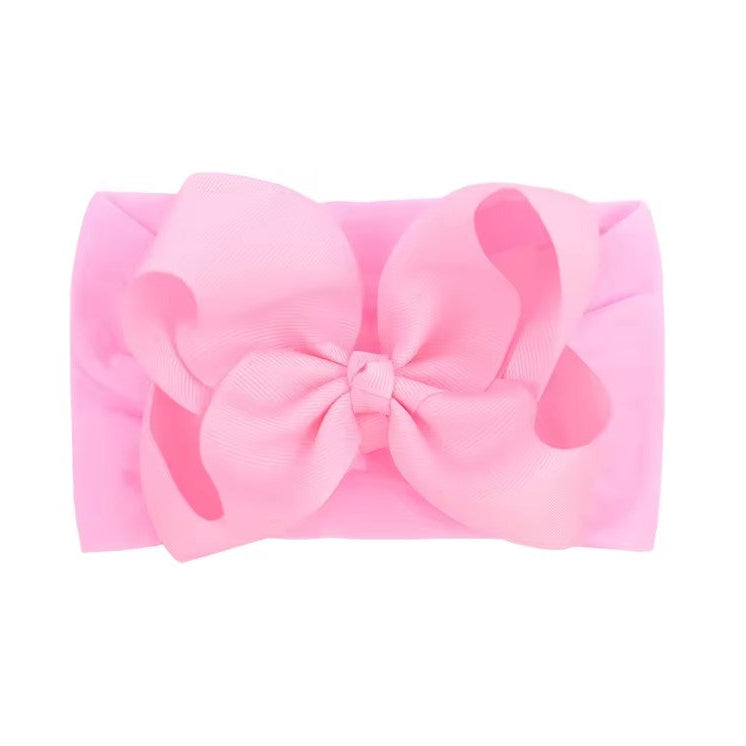 Pink headband with a large bow on a white background , large baby bow, baby headband