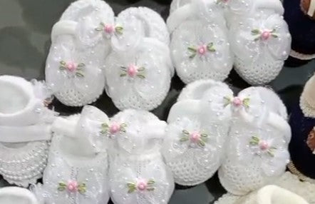 White decorative items with pink floral designs on a reflective surface