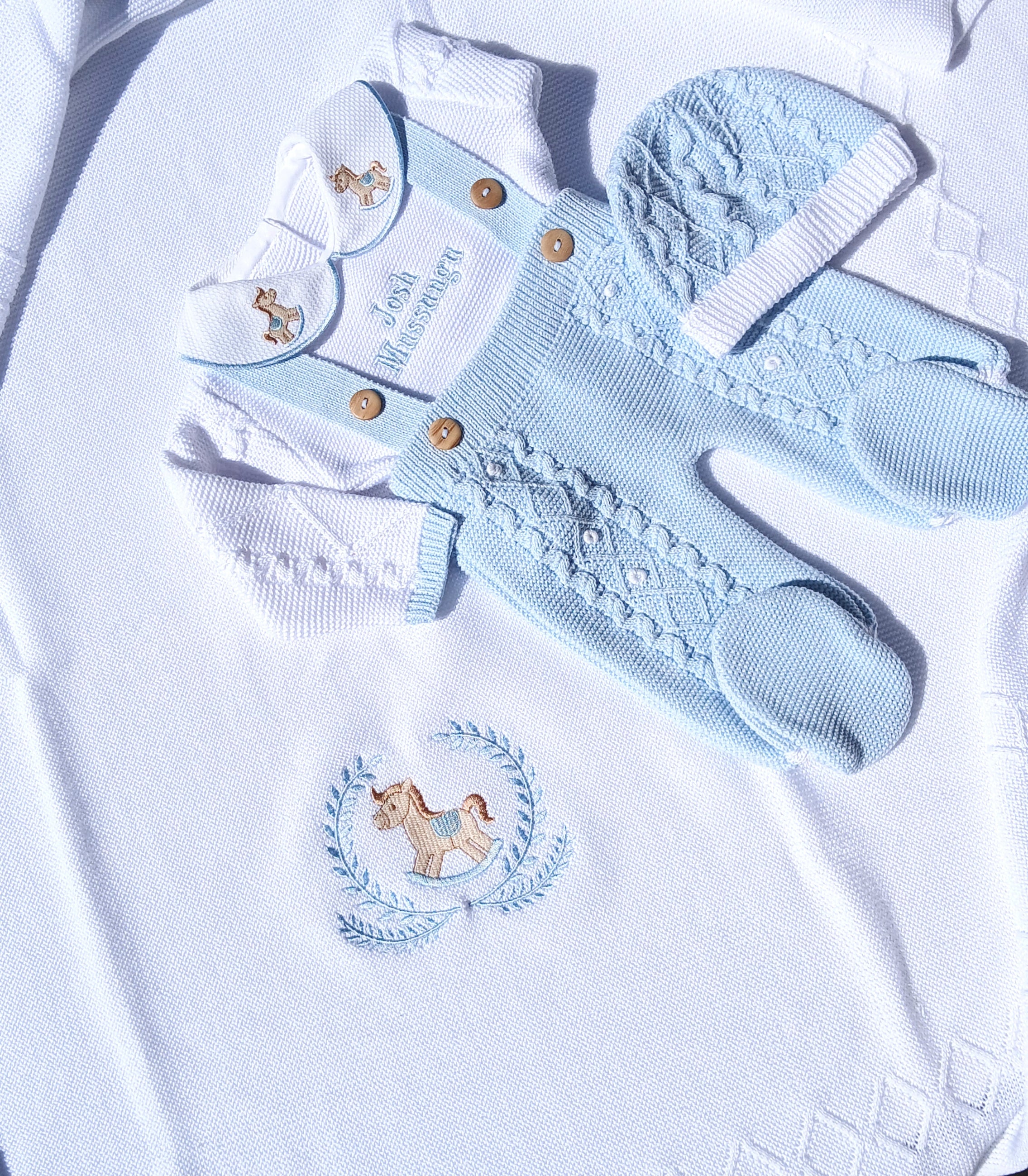 Baby blue outfit with embroidered design on a white background