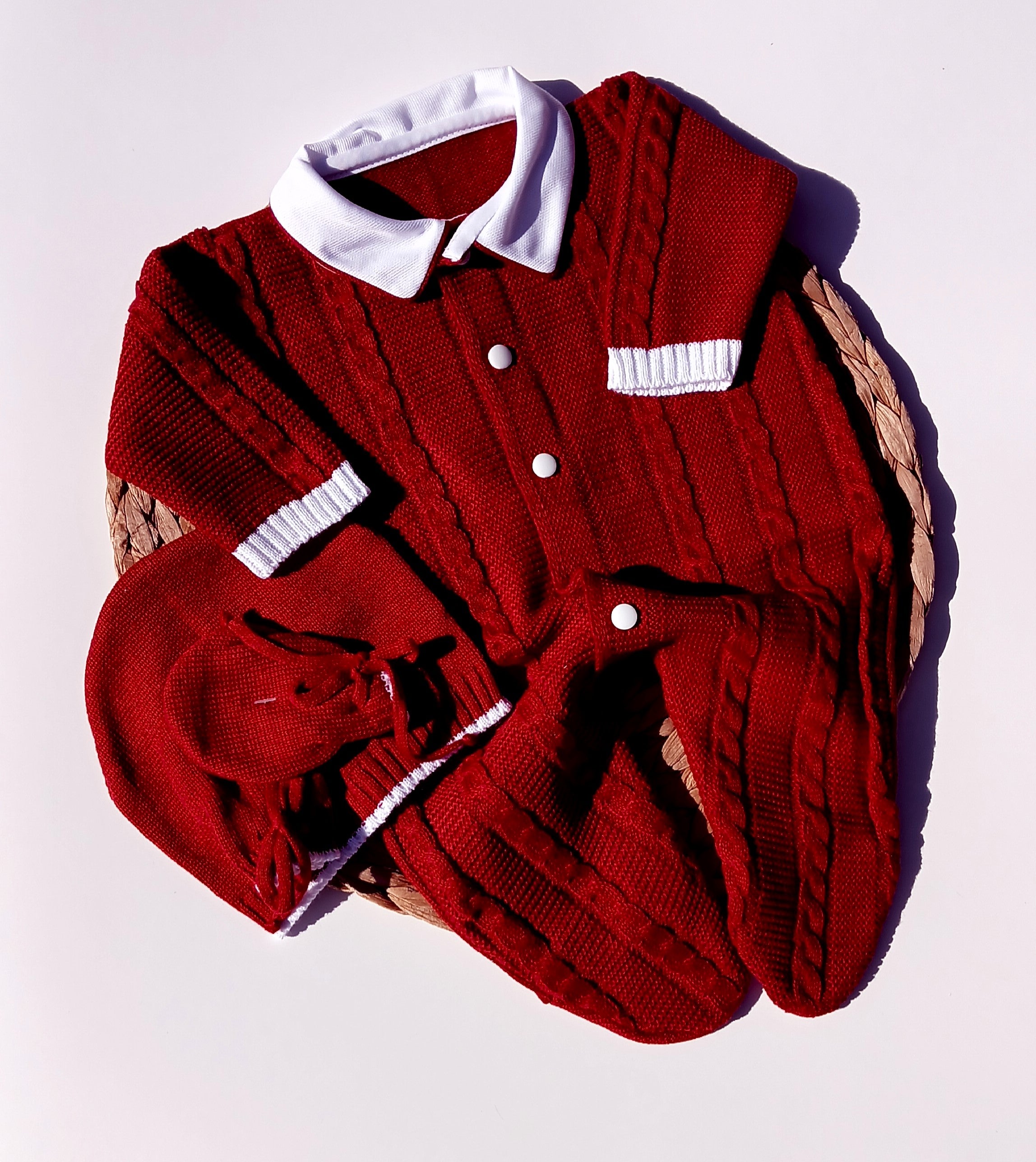 Red knitted cardigan with white buttons on a light purple background, Celebrate the season in style with this charming boys Christmas outfit