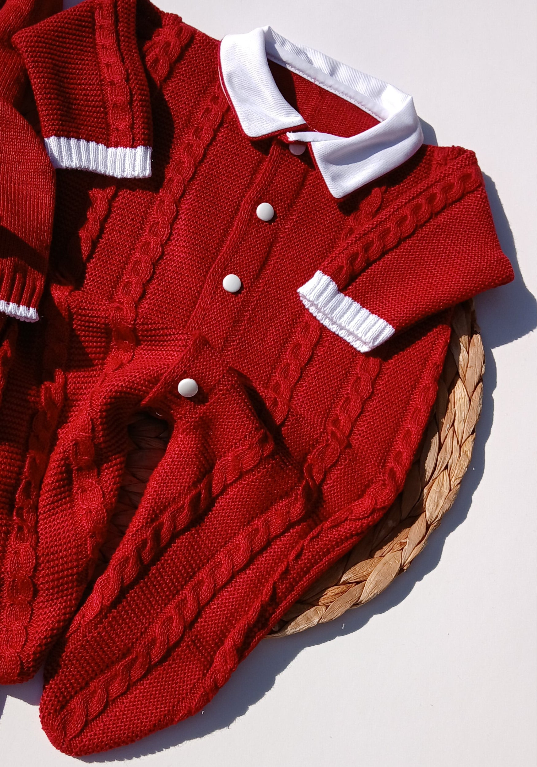 Red sweater with white buttons on a light background