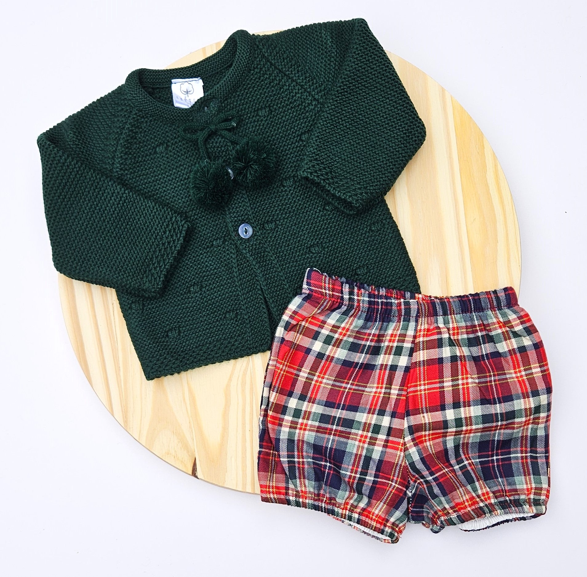 Celebrate the season in style with this charming girl Christmas outfit featuring a cozy knitted sweater paired with a coordinating plaid bloomers. This two-piece set keeps your little one comfortable and festive all day long. The classic color options make it perfect for holiday photos. Easy to dress and undress.