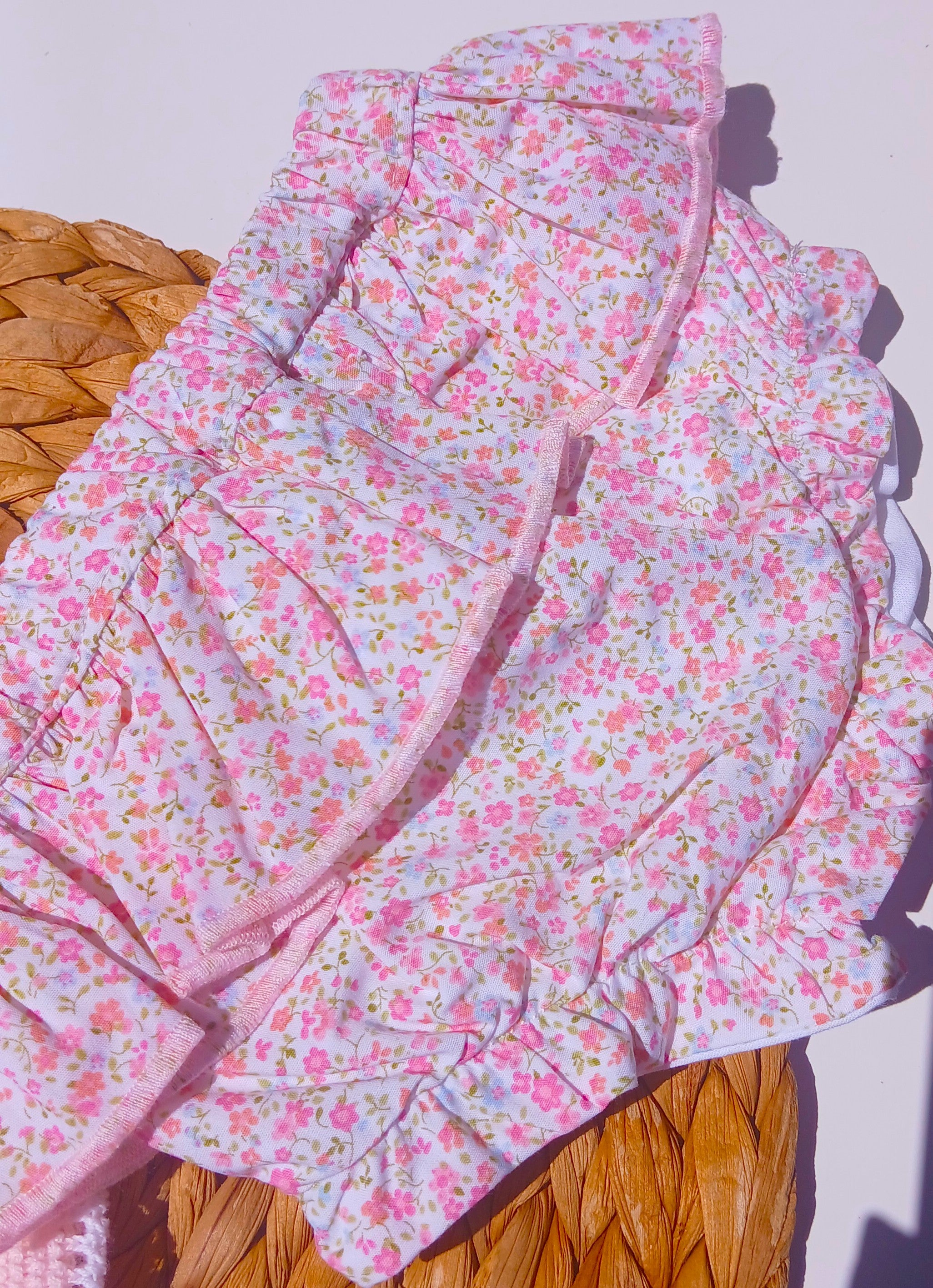 Floral-patterned quilt on a wooden surface with a white background