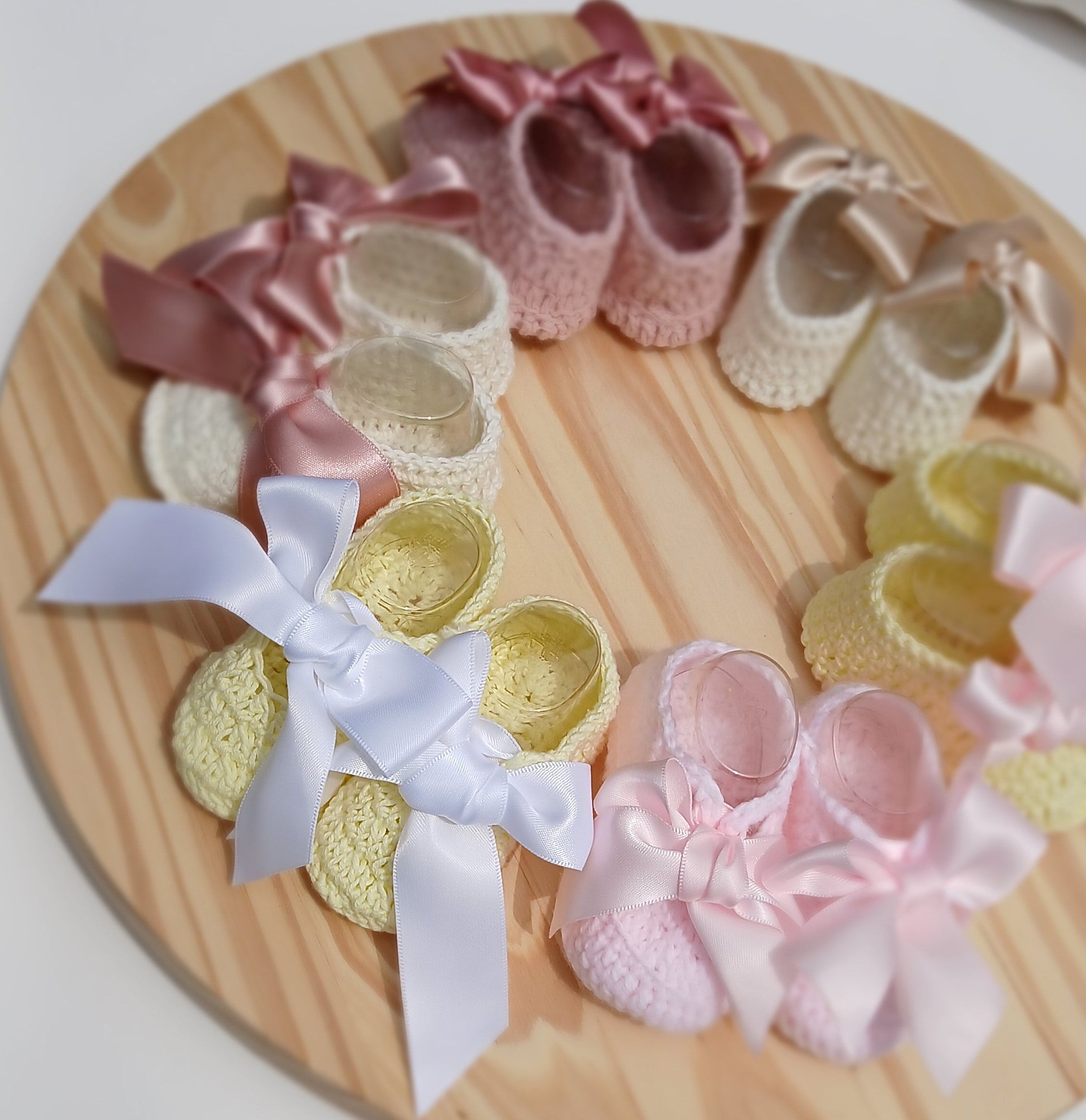 Set of baby shoes with ribbons on a wooden board