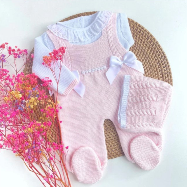 Pink baby romper with white ruffles on a woven mat with pink flowers. newborn knit going home outfit, newborn baby girl coming home knit outfit