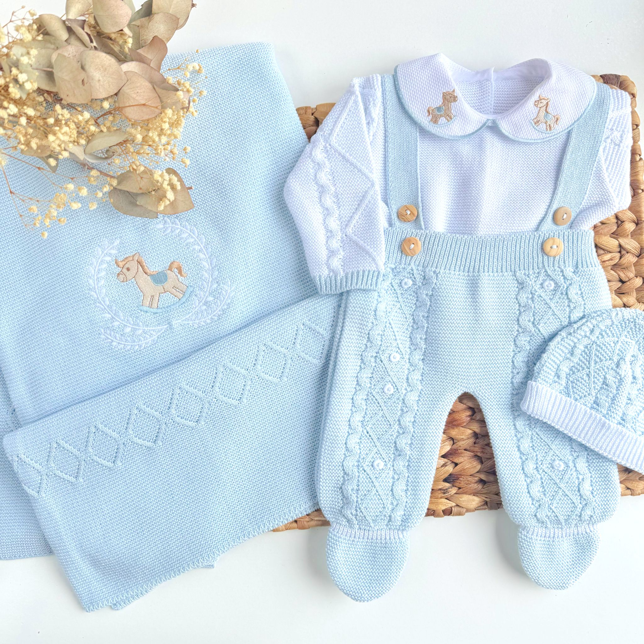 Light blue baby outfit with overalls and matching blanket on a white background