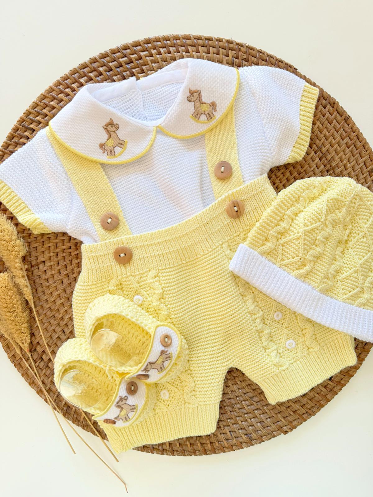 Yellow baby outfit with white shirt on a woven surface