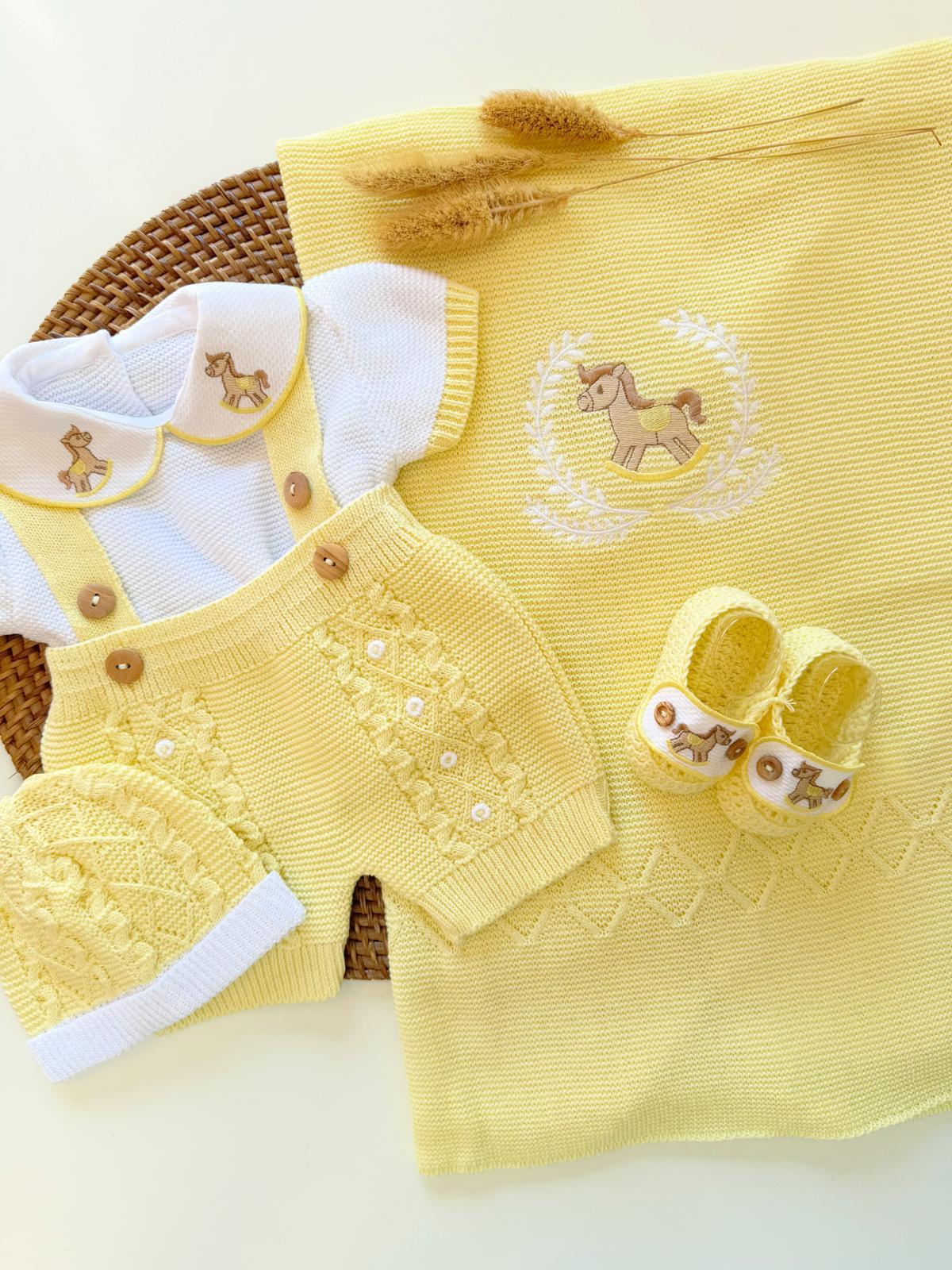 Yellow baby outfit with matching shoes and blanket on a white background