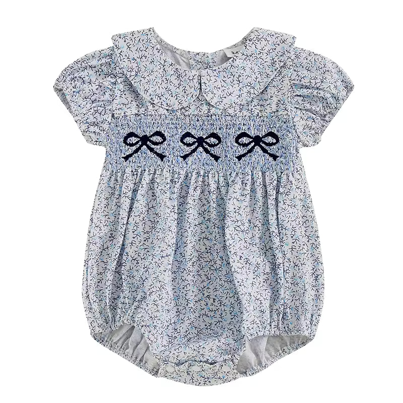 Floral baby romper with bow details on a white background