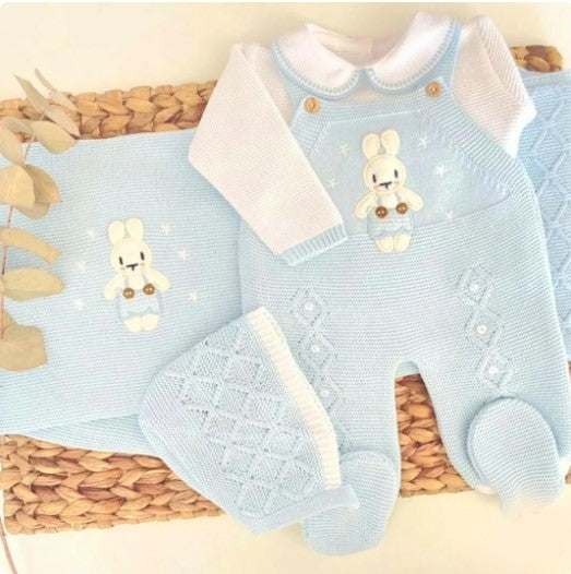 Blue baby romper with white collar and bunny design on a woven surface