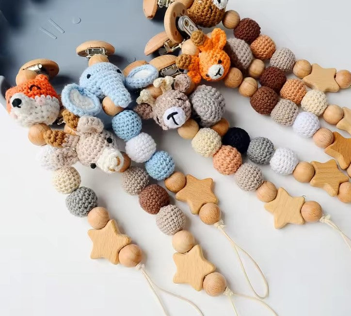elephant crochet  pacifier clip with beads and a small bag with teddy bear design on a white backgroundbackground