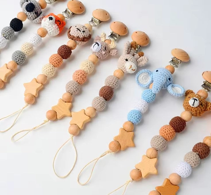 elephant crochet  pacifier clip with beads and a small bag with teddy bear design on a white background