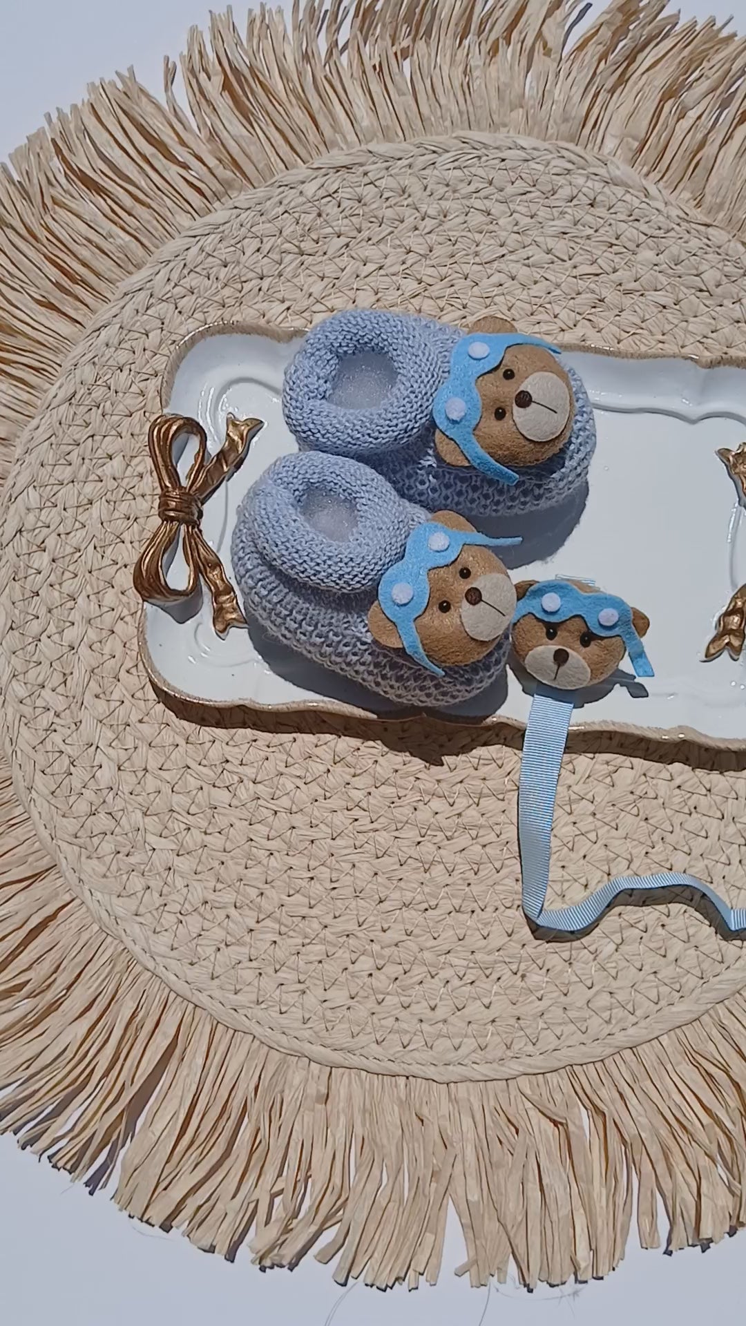 a pair of knit baby booties aviator with pacifier chain