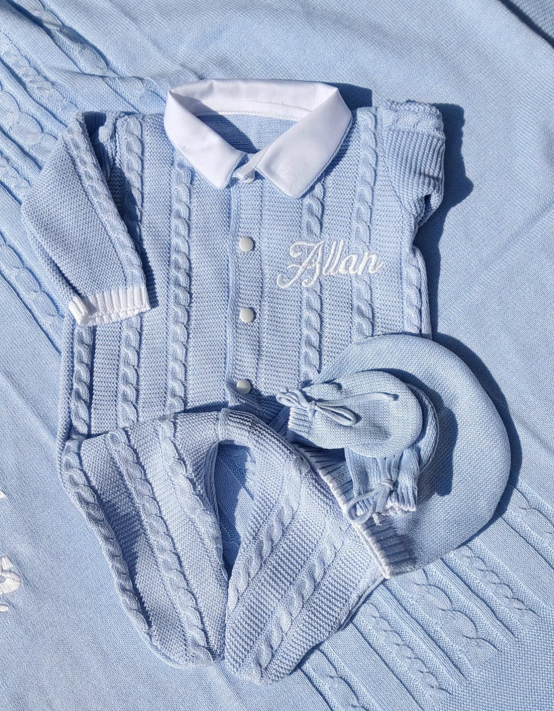 name personalized baby Blue knitted baby outfit with hat and mittens on a light blue blanket 